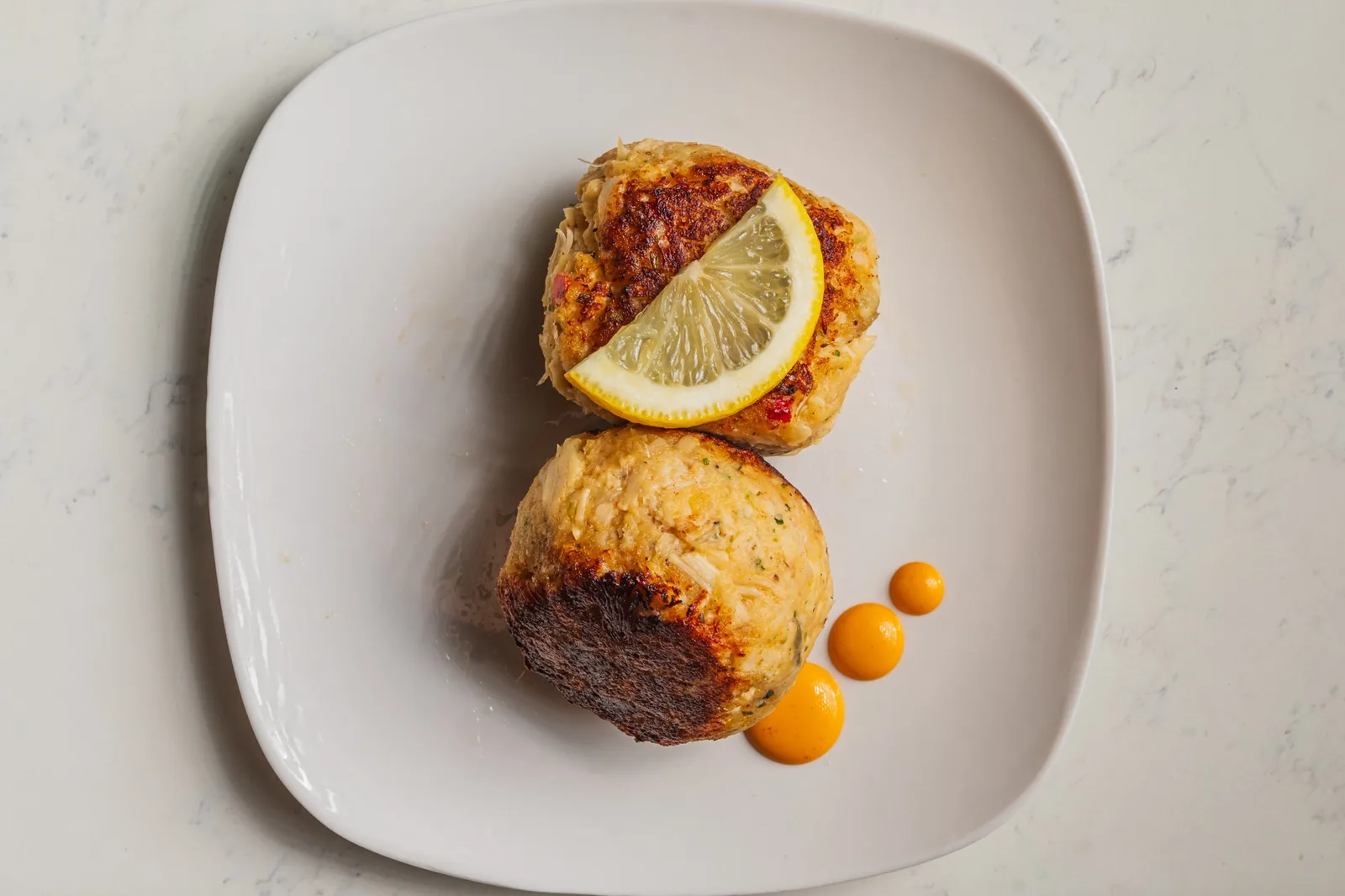 Two crab cakes with lemon